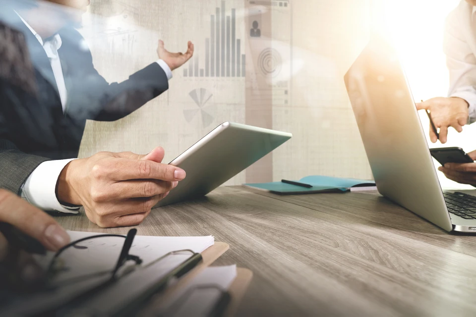 Homme d'affaires en costume présentant des données analytiques sur tablette numérique dans un bureau moderne