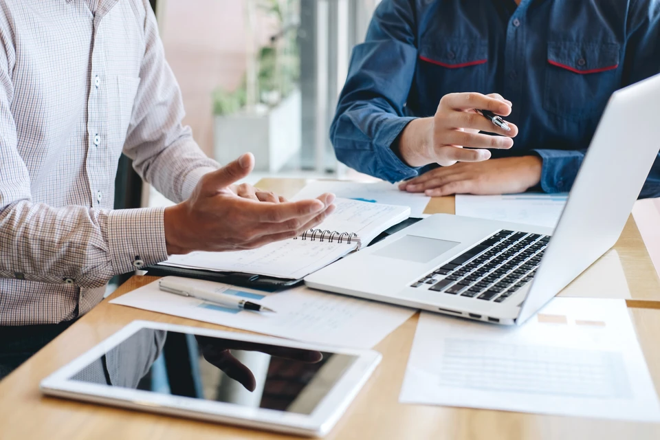 Écran d'ordinateur de bureau affichant clairement un devis informatique détaillé avec colonnes de services, tarifs, et options de solutions adaptées à différents budgets, dans un environnement de bureau professionnel avec accessoires (stylo, carnet). L'interface de logiciel de devis est visible, montrant des lignes de prestation informatique distinctes.